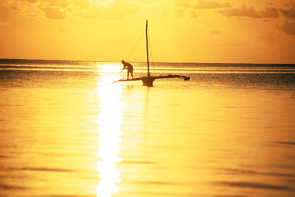 Outrigger canoe and fisherman in silhouette at sunrise off Jambiani, Zanzibar, Tanzania, East Africa, Africa