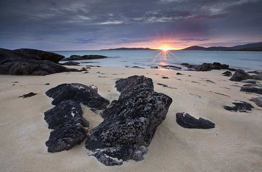 View towards Taransay at sunset from the rocky shore at Scarista, Isle of Harris, Outer Hebrides, Scotland, United Kingdom, Europe