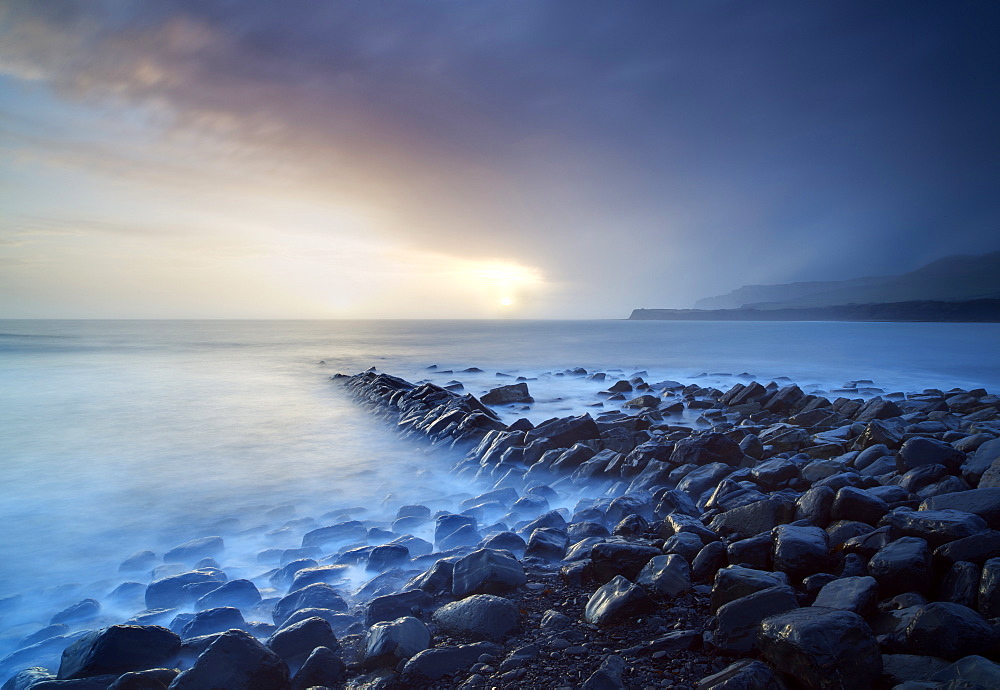 Sunset on a stormy winter's day looking across Kimmeridge Bay from the remains of Clavell's Pier, Kimmeridge, near Swanage, Dorset, England, United Kingdom, Europe