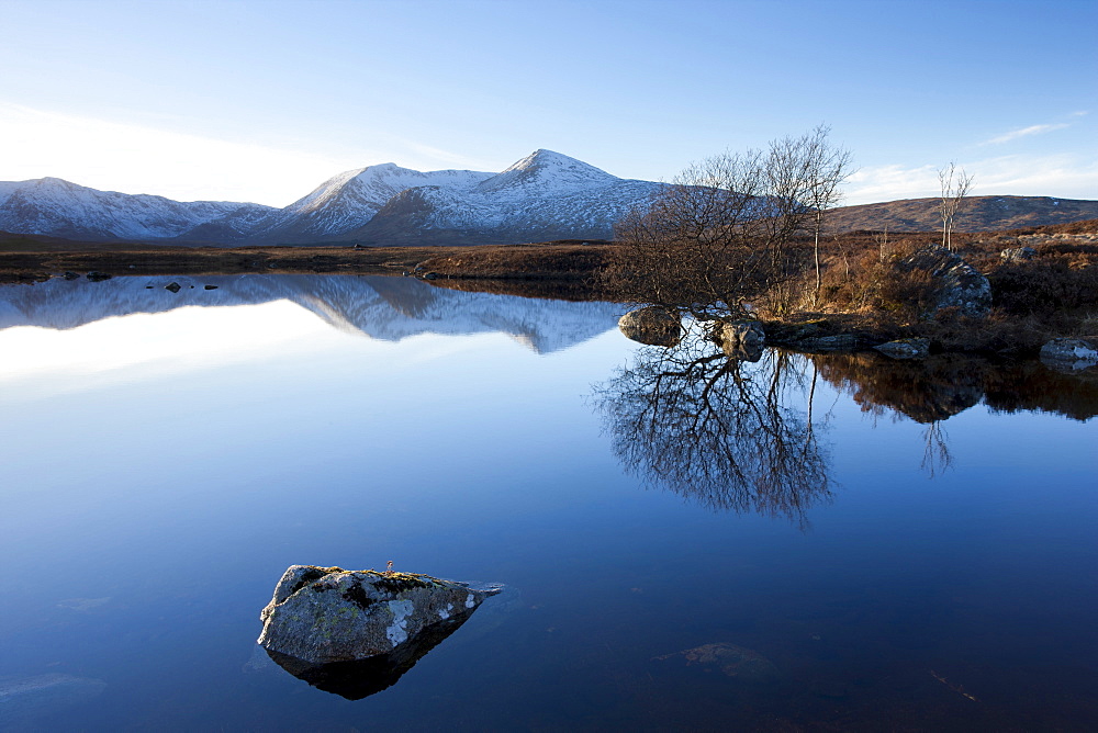 Dusk view of snow-covered Black Mount Hills and their reflection in the flat calm Lochain na h'Achlaise, Rannoch Moor, Highland, Scotland, United Kingdom, Europe