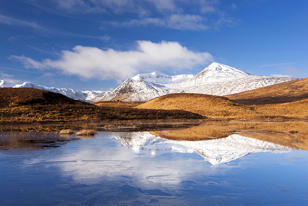 Black Mount Hills covered in snow on a sunny winter's day with reflections in a frozen Lochain, Rannoch Moor, Highland, Scotland, United Kingdom, Europe