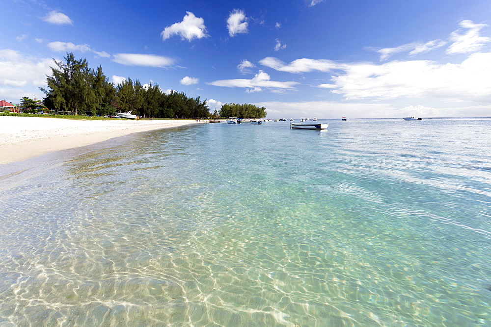 View along Flic en Flac Beach showing the clear shallows of the Indian Ocean, blue sky and white sand, on the west coast of Mauritius, Indian Ocean, Africa