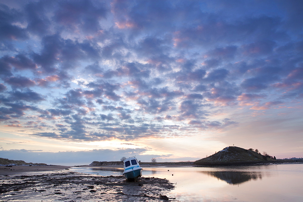 View towards Church Hill and the Aln Estuary during a stunning winter sunrise from the beach at low tide with a fishing boat in the foreground, Alnmouth, near Alnwick, Northumberland, England, United Kingdom, Europe