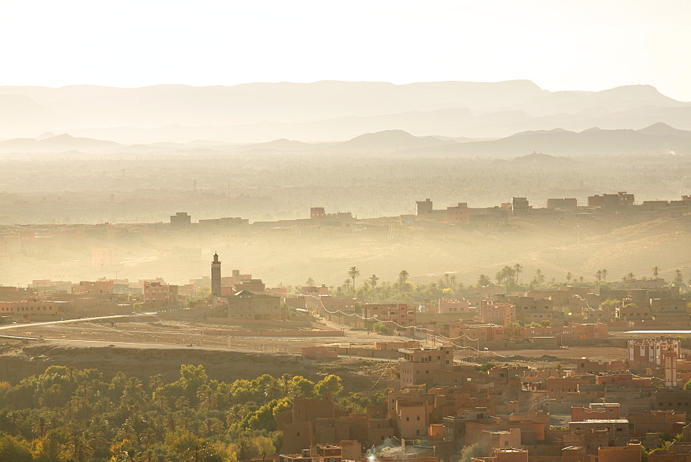 View over the town of Tinerhir soon after sunrise showing smoke rising from the streets and traditional houses bathed in sunlight, Tinerhir, Sousse-Massa-Draa, Morocco, North Africa, Africa