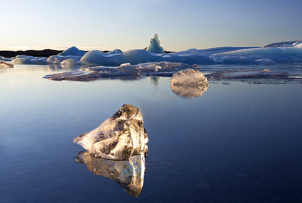 View of icebergs on Jokulsarlon, a glacial lagoon at the head of the Breidamerkurjokull Glacier, with some icebergs illuminated by the afternoon winter sun, on the edge of the Vatnajokull National Park, South Iceland, Iceland, Polar Regions