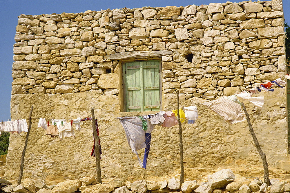 Washing line in front of an old stone wall with small window at Kastri on Gavdos, Greece, Europe