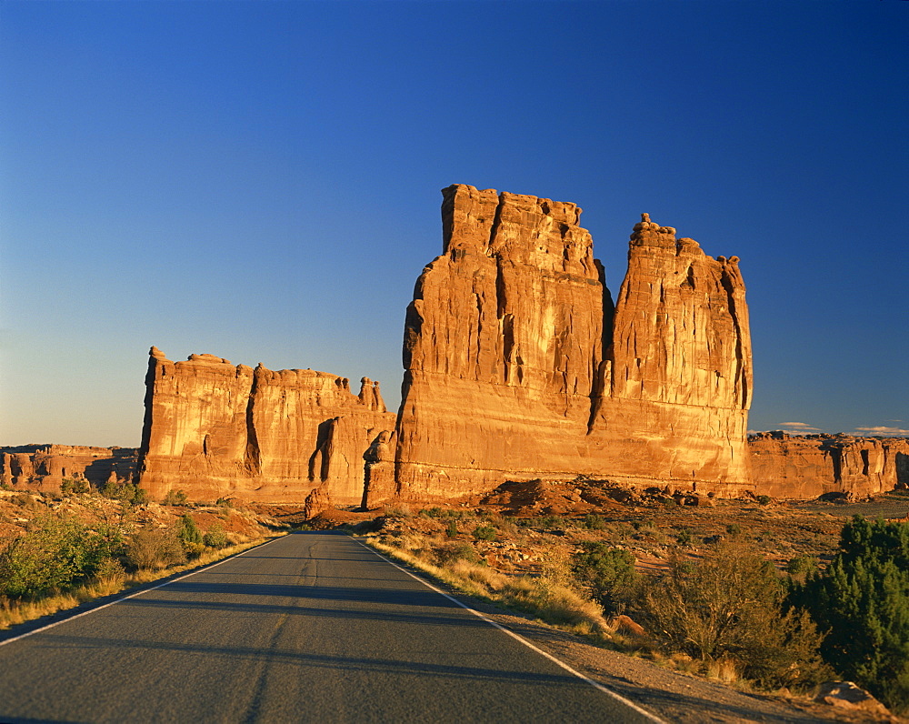 Road leading to tall rock formations in the desert in Utah, United States of America, North America