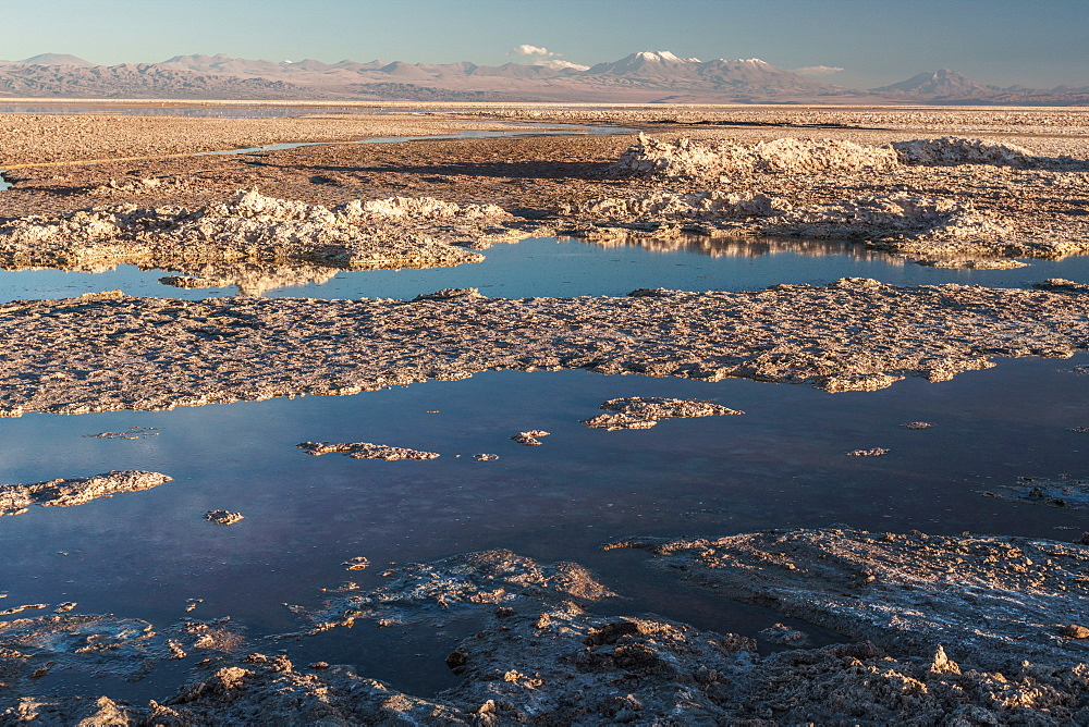 Salt residue piled up by Laguna Chaxa, Atacama Salt Flats, with snow-capped volcanoes, near San Pedro de Atacama, Chile, South America