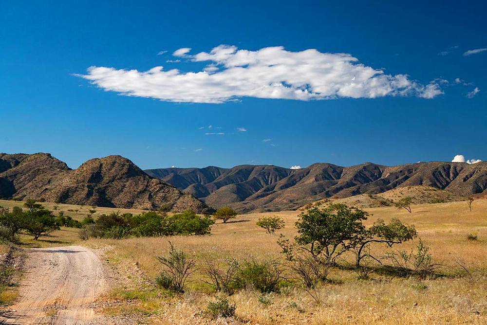 Dramatic cloud over green and mountainous landscape, north of Sesfontein, Namibia, Africa