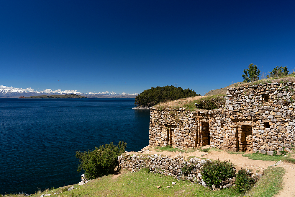 View across deep blue Lake Titicaca with the ruins of the Inca Pilocaina Sun Temple, from Sun Island, Lake Titicaca, Bolivia, South America