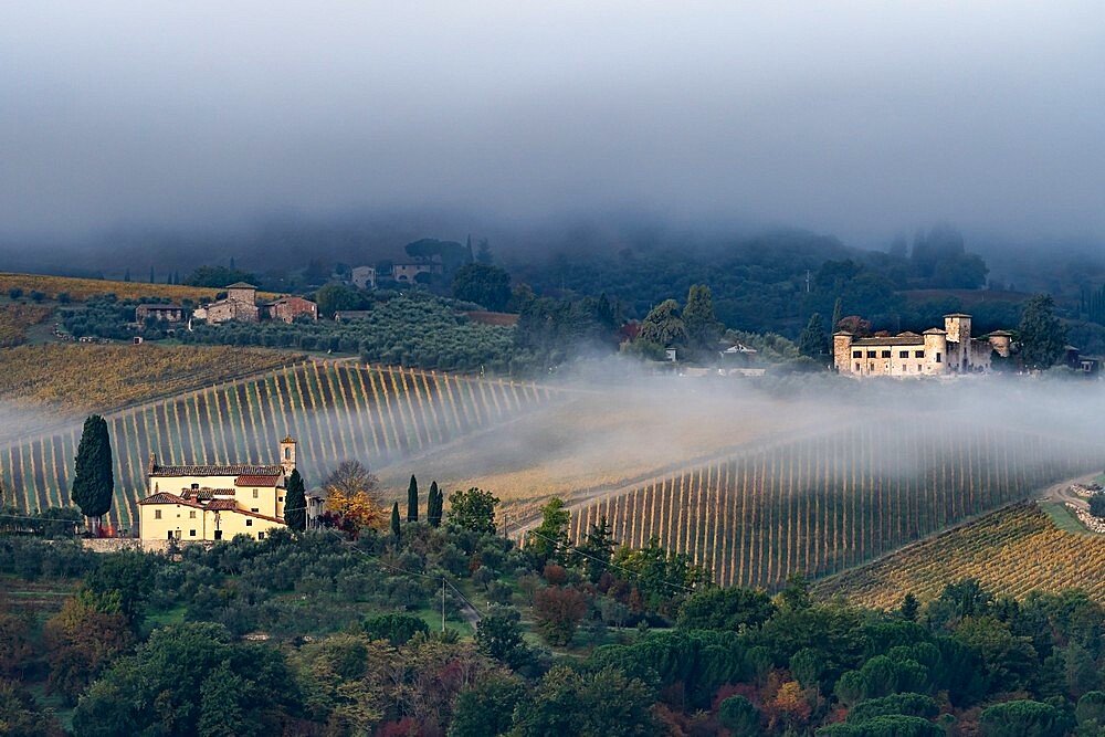 Castello di Gabbiano across a misty valley, church in foreground, San Casciano, Tuscany, Italy, Europe