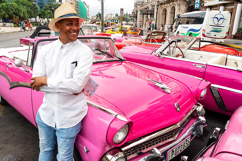 Taxi driver amidst many parked classic cars, Havana, Cuba