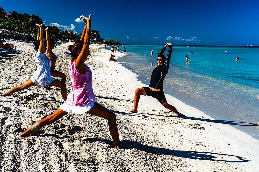 Enthusiastic stretching class to keep fit on the beach, Varadero, Cuba