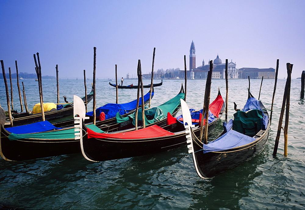 View past docked gondolas towards St.Mark's Square, from across the Grand Canal, Venice, Veneto, Italy 