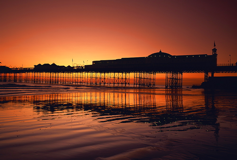 Reflections in the sea of the pier at Brighton at sunset, Sussex, England, United Kingdom, Europe