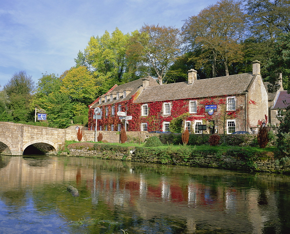 The Swan Hotel reflected in the river at Bibury in the Cotswolds, Gloucestershire, England, United Kingdom, Europe