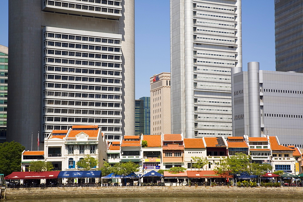 Boat Quay Conservation Area bars and restaurants in colourful historic buildings on south bank of River with towering skyscrapers of Raffles Place in downtown Central Business District behind, Singapore, Southeast Asia, Asia