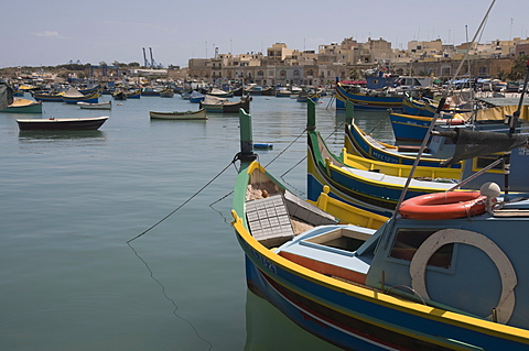 Brightly coloured fishing boats called Luzzus at the fishing village of Marsaxlokk, Malta, Mediterranean, Europe