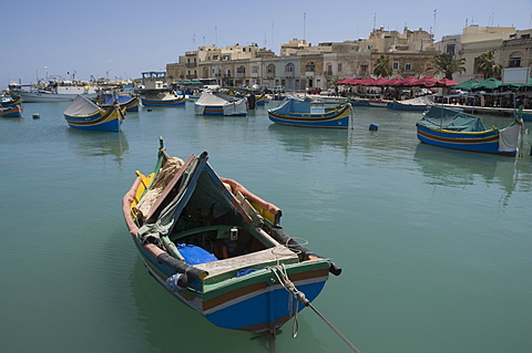 Brightly coloured fishing boats called Luzzus at the fishing village of Marsaxlokk, Malta, Mediterranean, Europe