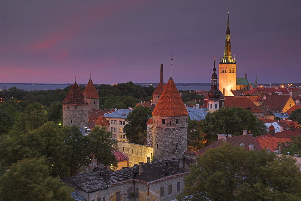 Medieval town walls, defence towers and spire of St. Olav's church at sunset, Tallinn, Estonia, Baltic States, Europe