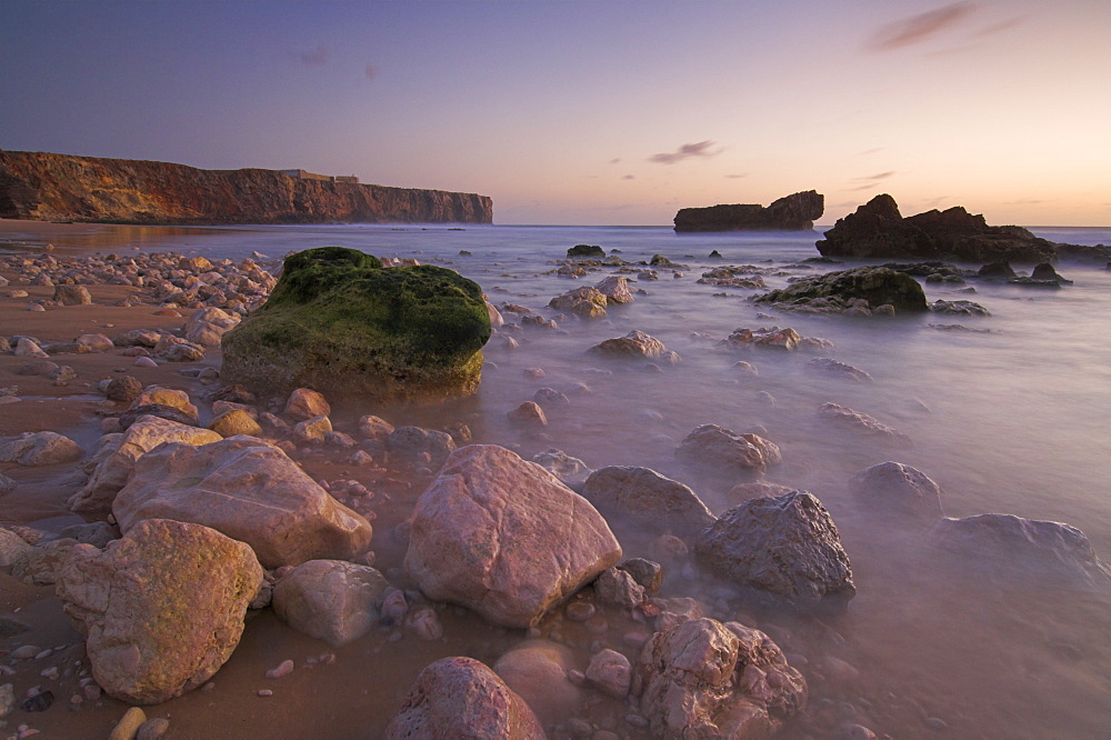 Long exposure of incoming tide on Tonal beach at sunset near Sagres, Algarve, Portugal, Europe