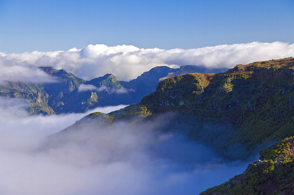 Mountains of the Serra de Aqua valley, looking towards the south coast, and Boca da Ecumeada (Ecumeada Pass), above the clouds, Madeira, Portugal, Europe