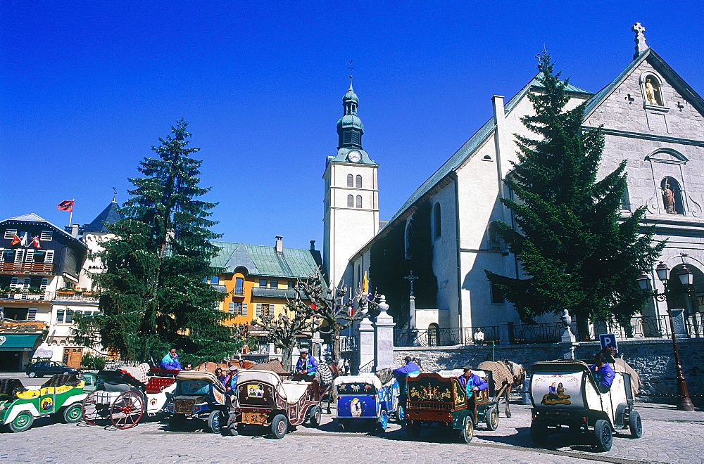 France, Alps, Haute-Savoie, Megeve, Row Of Horse Sleighs Park On The Main Square