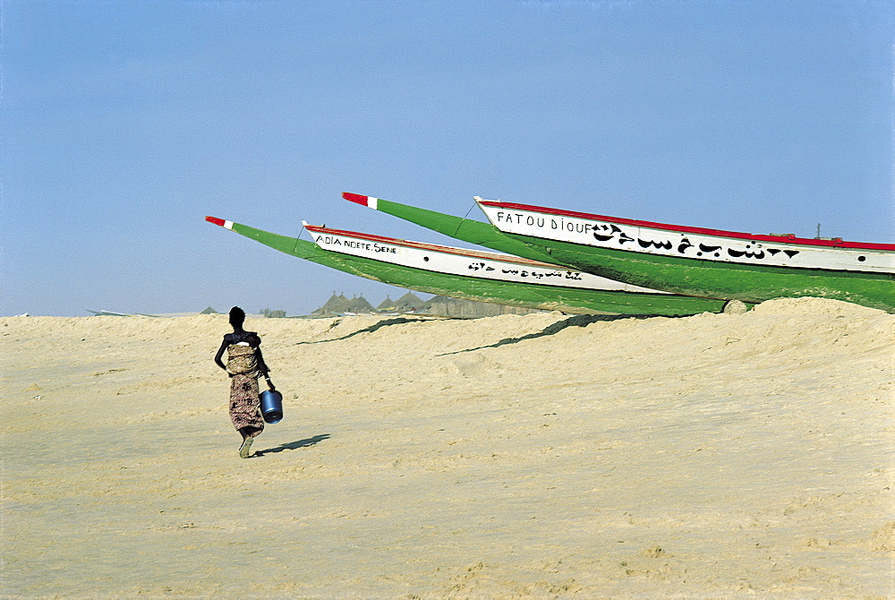 Senegal, Cayar, Fishing Outriggers Ashore, Woman Walking On The Beach, 