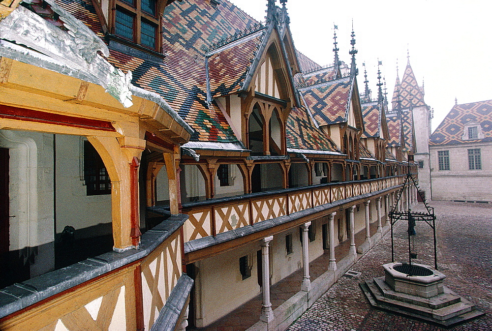 France, Burgondy, Cty Of Beaune, The Medieval Hospital With Varnished Tiles & Gargoyle At Fore On A Hazy Day