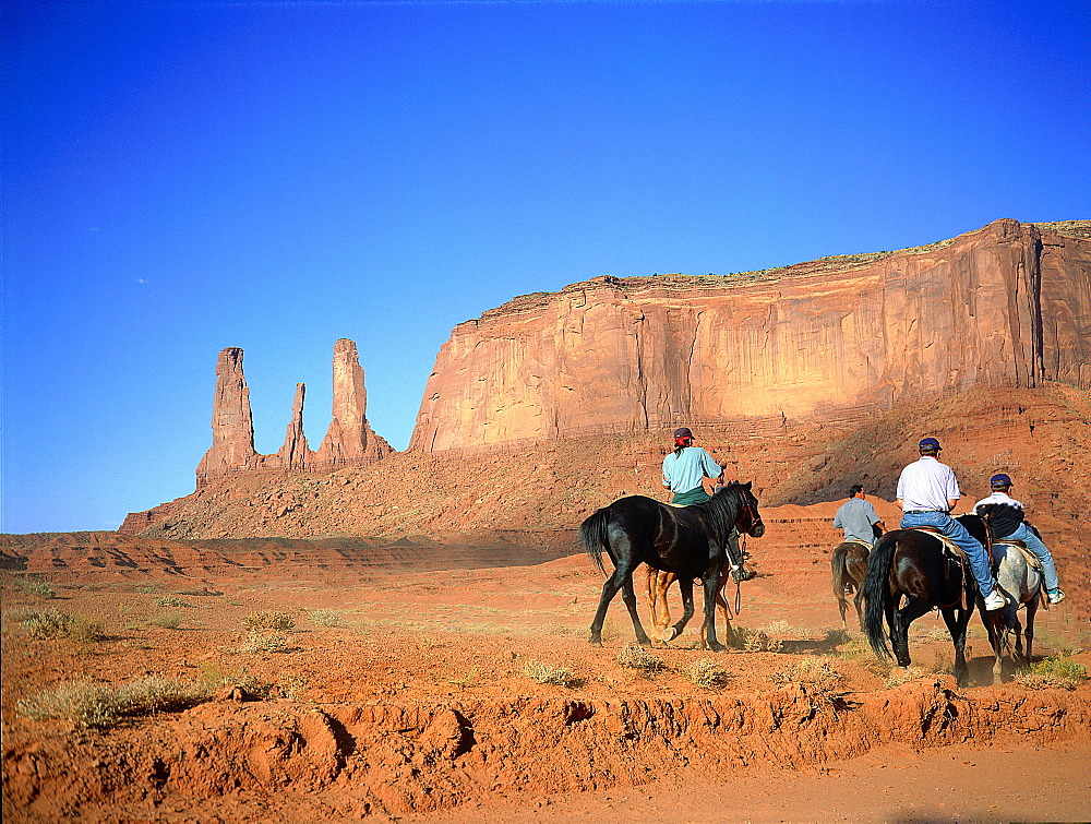 Usa, South West, Arizona & Utah, Navajo Reservation Of Monument Valley, The Three Sisters Red Rocks Peaks (Mesas), Tourist Visiting On Horseback