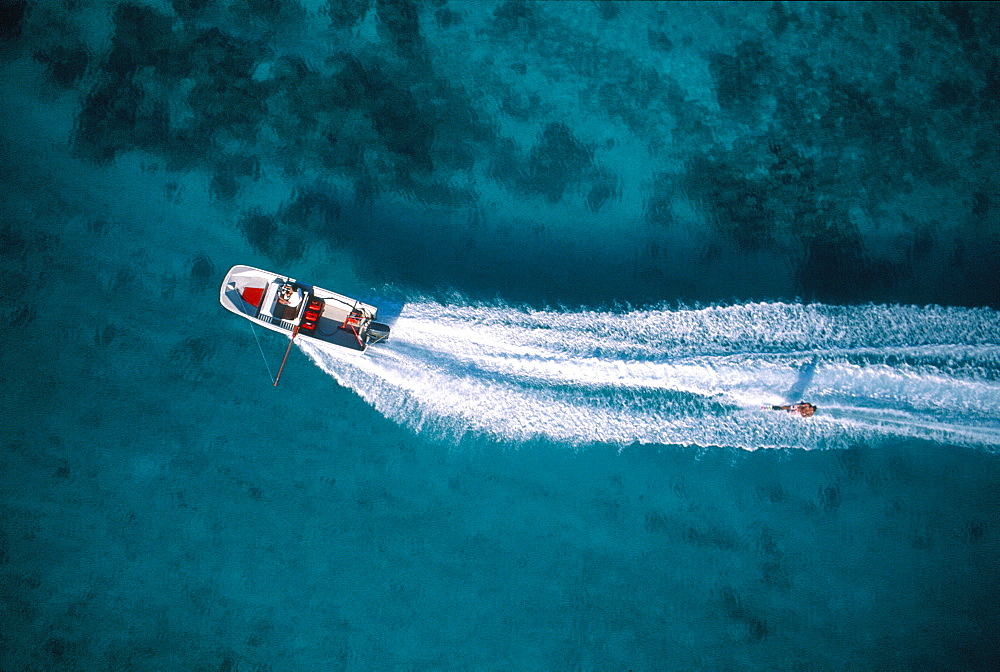 French Polynesia, Windward Islands, Moorea, Aerial Of A Boat Pulling A Waterskier On The Lagoon