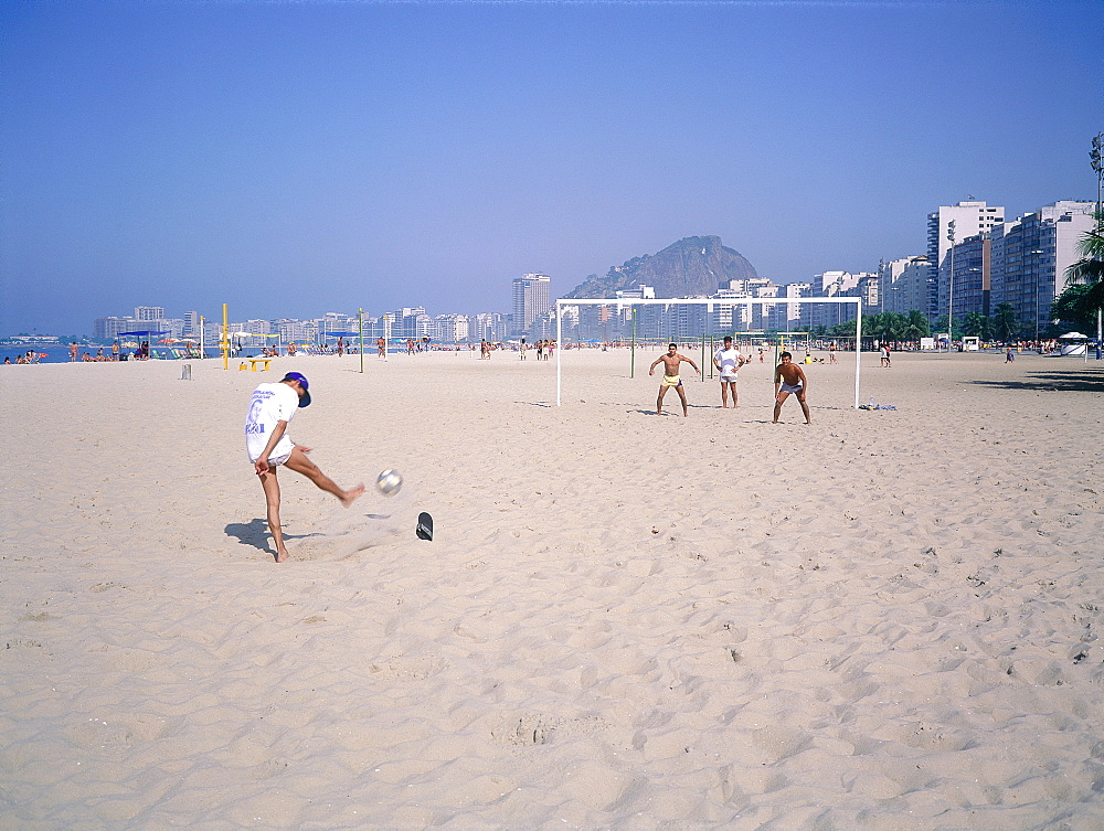 Brazil, Riodejaneiro, Copacabana Beach, Children Playing Football On The Beach