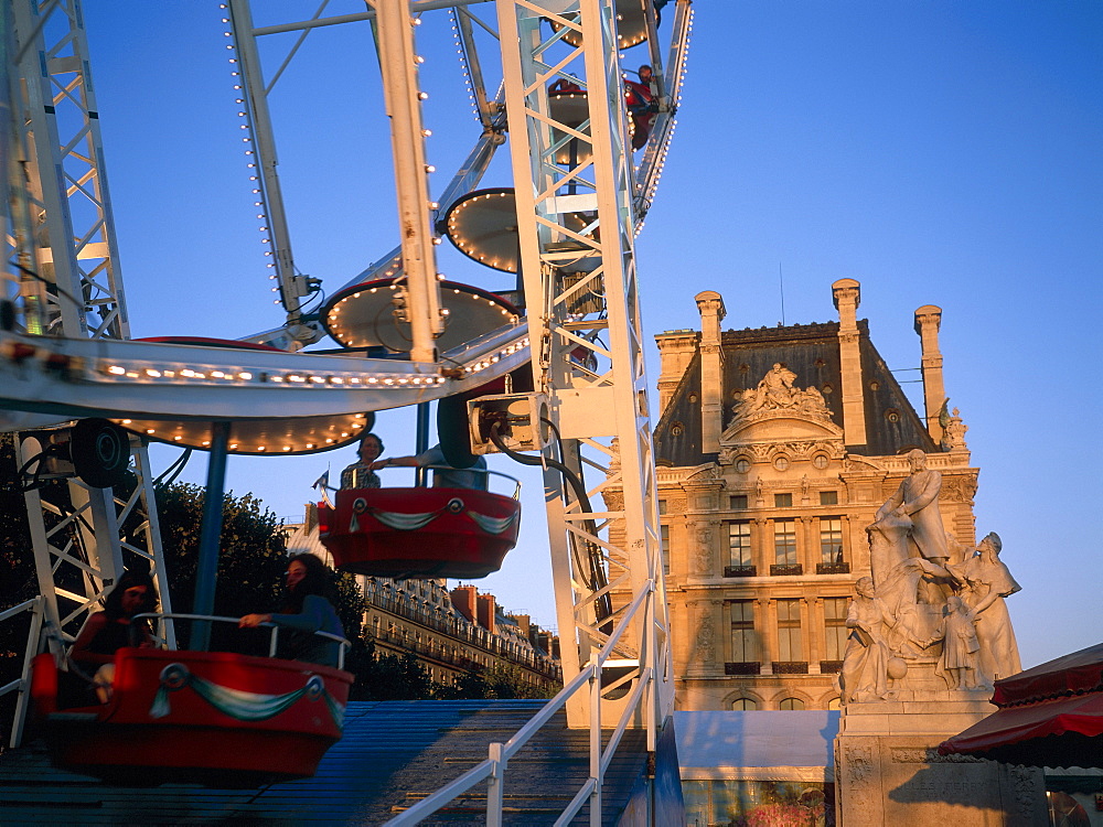 Merry-go-round and ferris wheel at dusk in the Tuileries Park, Paris, France, Europe