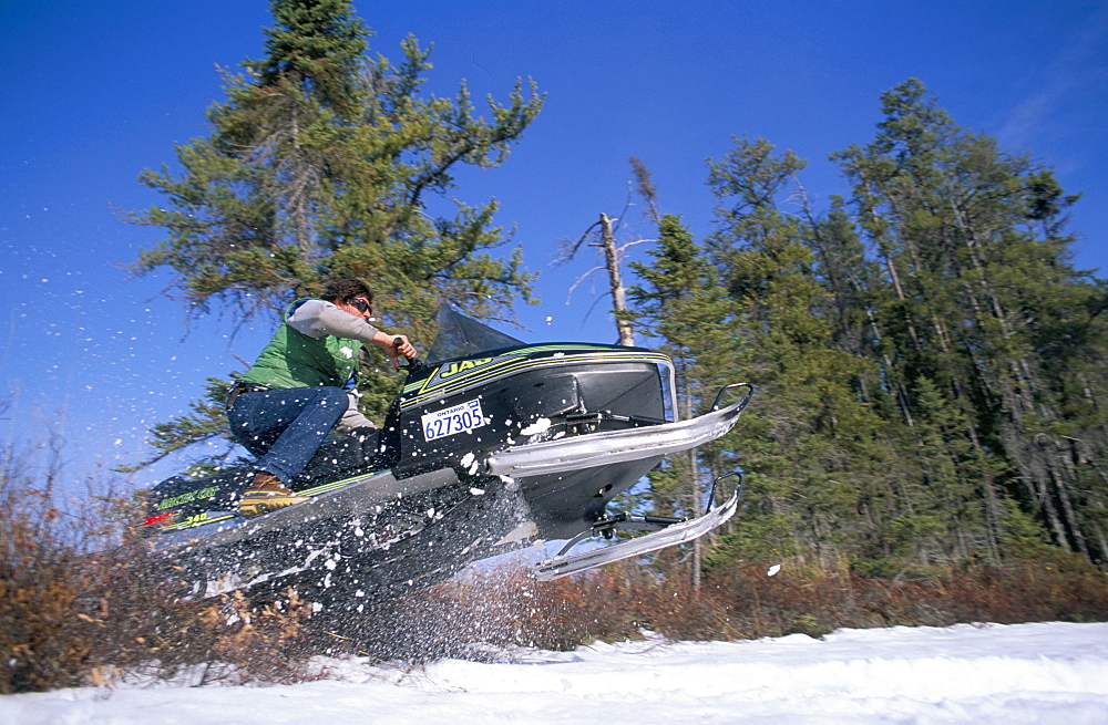 Snowmobile travelling at speed, Sunset Country, Ontario, Canada, North America