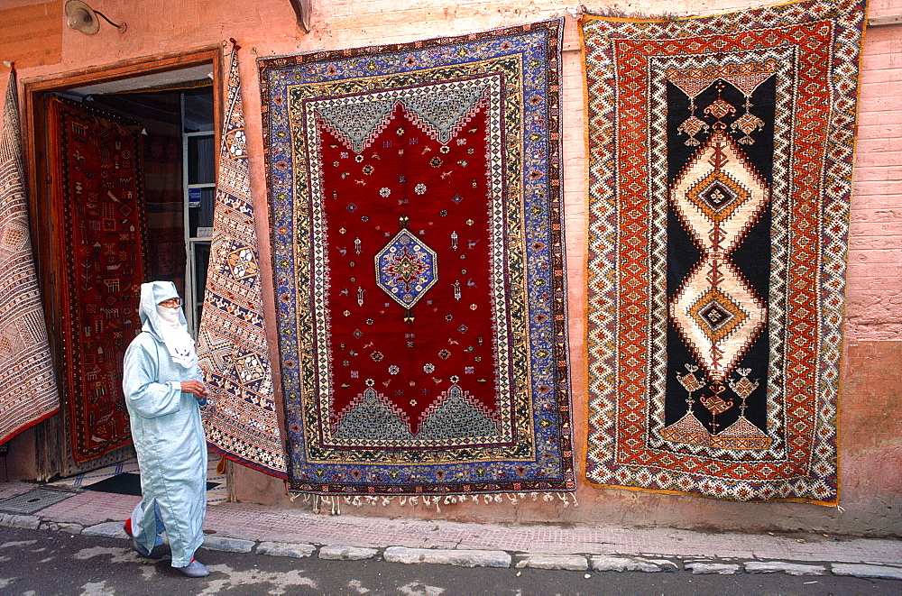 Morocco, Rabat, Medina, Woman Wearing Traditional Veil Passing By A Carpets Dealer