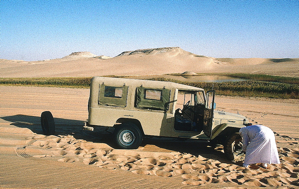 Algeria, Sahara, Djanet Oasis, Tuareg Changing A Flat Tire Of His 4 Wheel Drive 