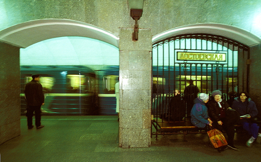 Russia, Saint Petersburg, The Underground Subway, Train & Women Waiting On A Bench 