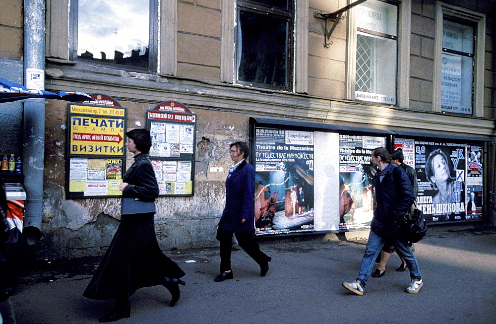 Russia, Saint Petersburg, Passers By, Ad Posters At Wall Behind 