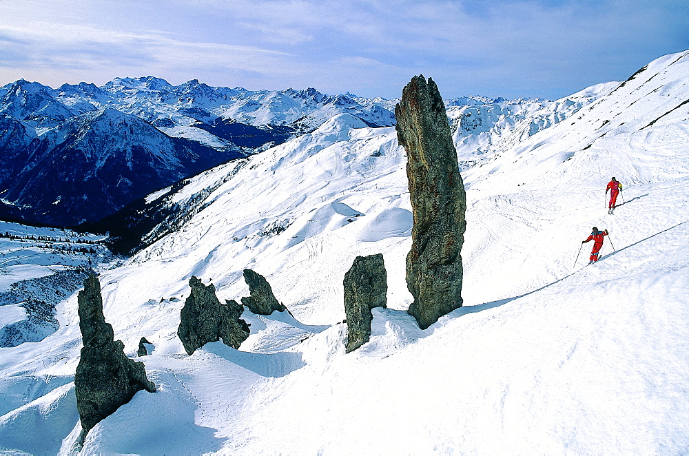 France, Alps In Winter, Two Skiers In Mountains Landscape With Rocks 