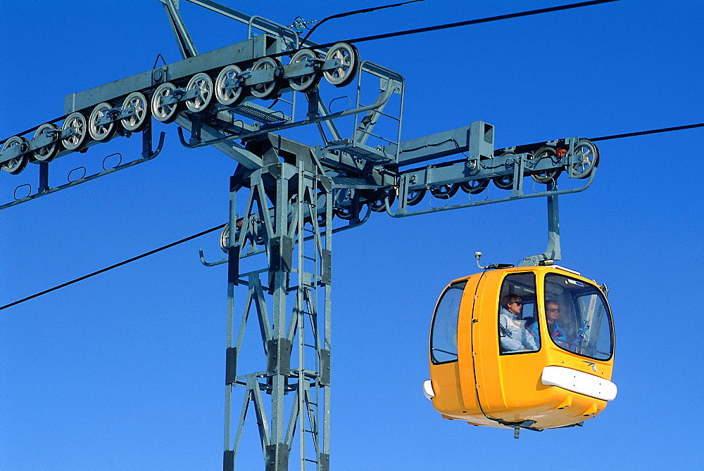 France, Alps In Winter, Cable Car Pile And Yellow Cabin In A Ski Resort 