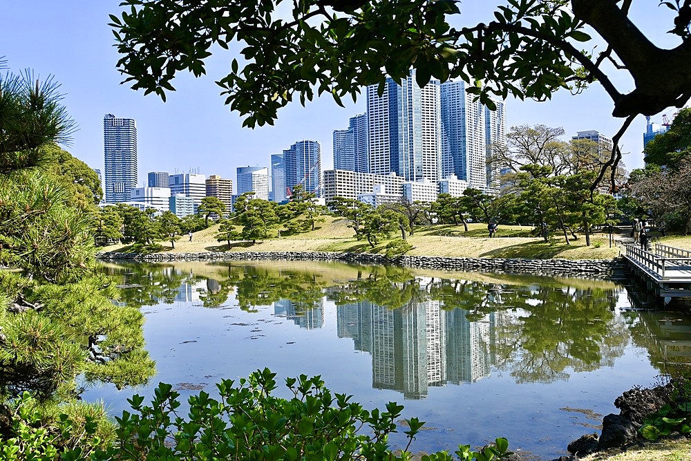 Buildings reflecting on lake in Hamarikyu Gardens