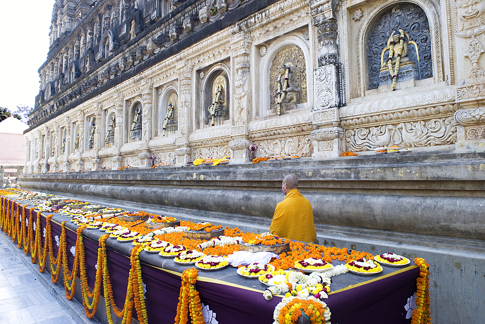 Flower offerings and a monk at the Buddhist Mahabodhi Mahabihara Temple (Great Stupa), Bodh Gaya, UNESCO World Heritage Site, Bihar, India, Asia