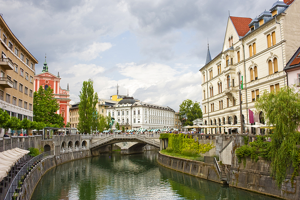 A stretch of the River Ljubljanica leading towards the Triple Bridge, designed in 1932 by Joze Plecnik, and city centre, Ljubljana, Slovenia, Europe