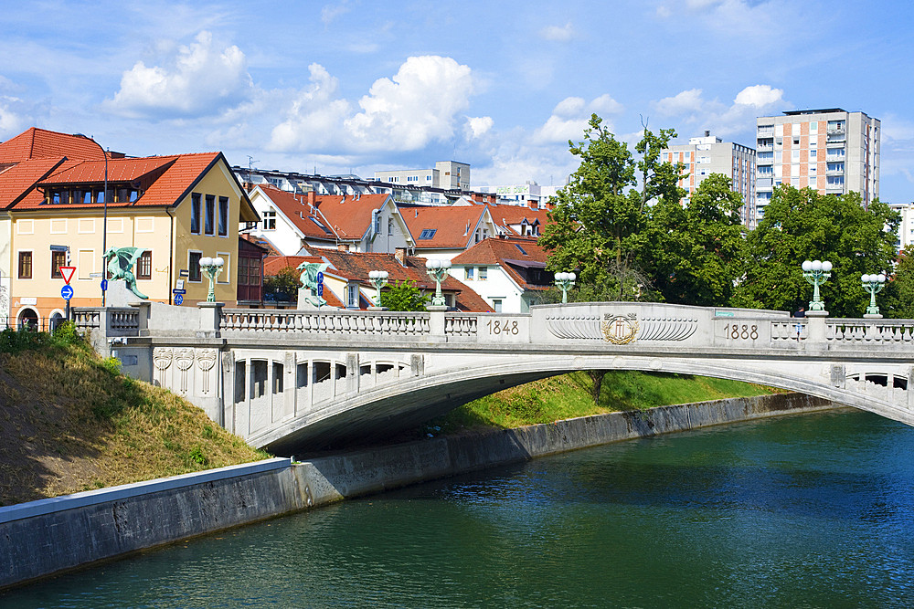 View of the famous single arch Dragon Bridge, guarded by four fearsome dragon statues, crossing the River Ljubljanica to connect Kopitar Street with Ressel Street and central market, Ljubljana, Slovenia, Europe