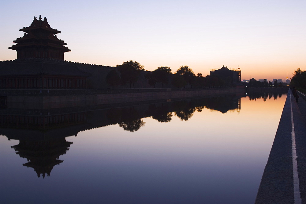 A reflection of a watch tower on the wall of the Forbidden City Palace Museum, silhouetted at dusk, Beijing, China, Asia