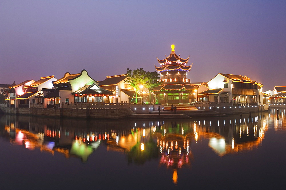 Traditional old riverside houses and pagoda illuminated at night in Shantang water town, Suzhou, Jiangsu Province, China, Asia