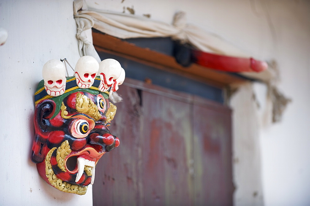 Mask and phallus hanging on a door to protect its occupants, near the temple of the Divine Madman, Metshina, Punakha, Bhutan