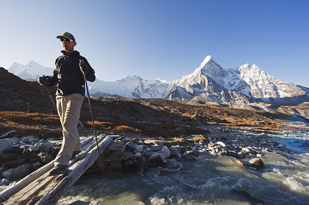 Trekker crossing a mountain stream, Ama Dablam, 6812m, Solu Khumbu Everest Region, Sagarmatha National Park, Himalayas, Nepal, Asia