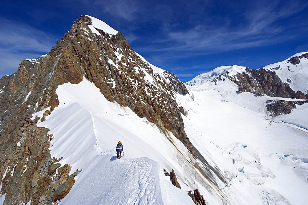 Climber on snow ridge, Aiguille de Bionnassay on the route to Mont Blanc, French Alps, France, Europe