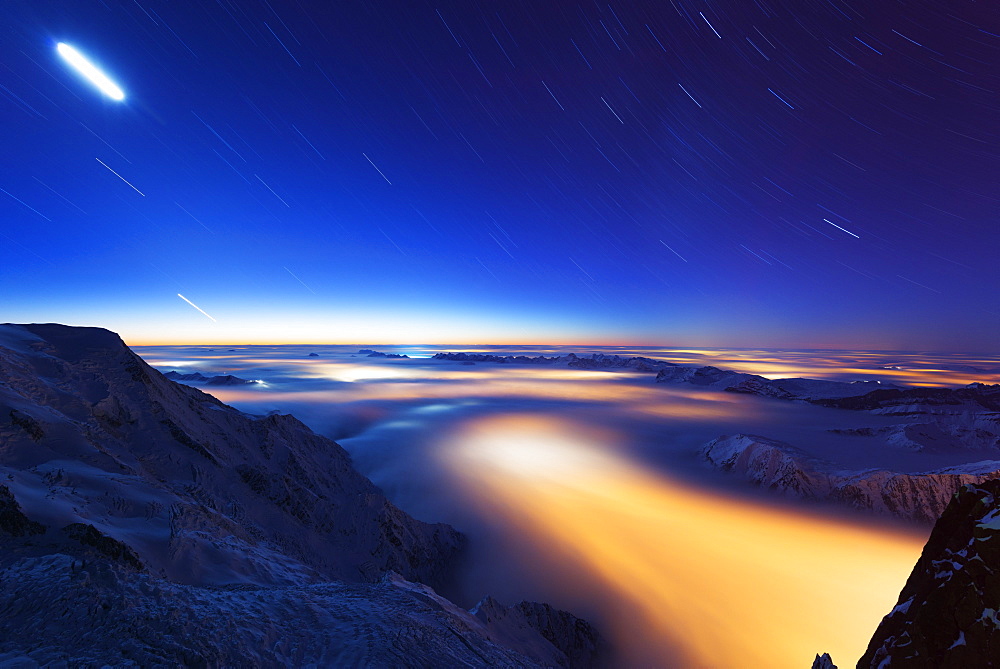 Sea of clouds weather inversion over Chamonix valley, star and moon light trails, Chamonix, Rhone Alpes, Haute Savoie, France, Europe